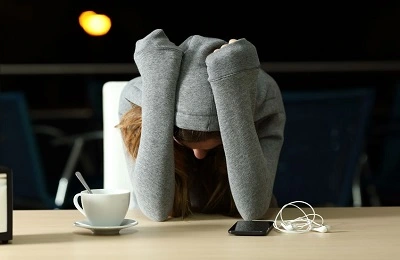 Frau sitzt weinend am Tisch